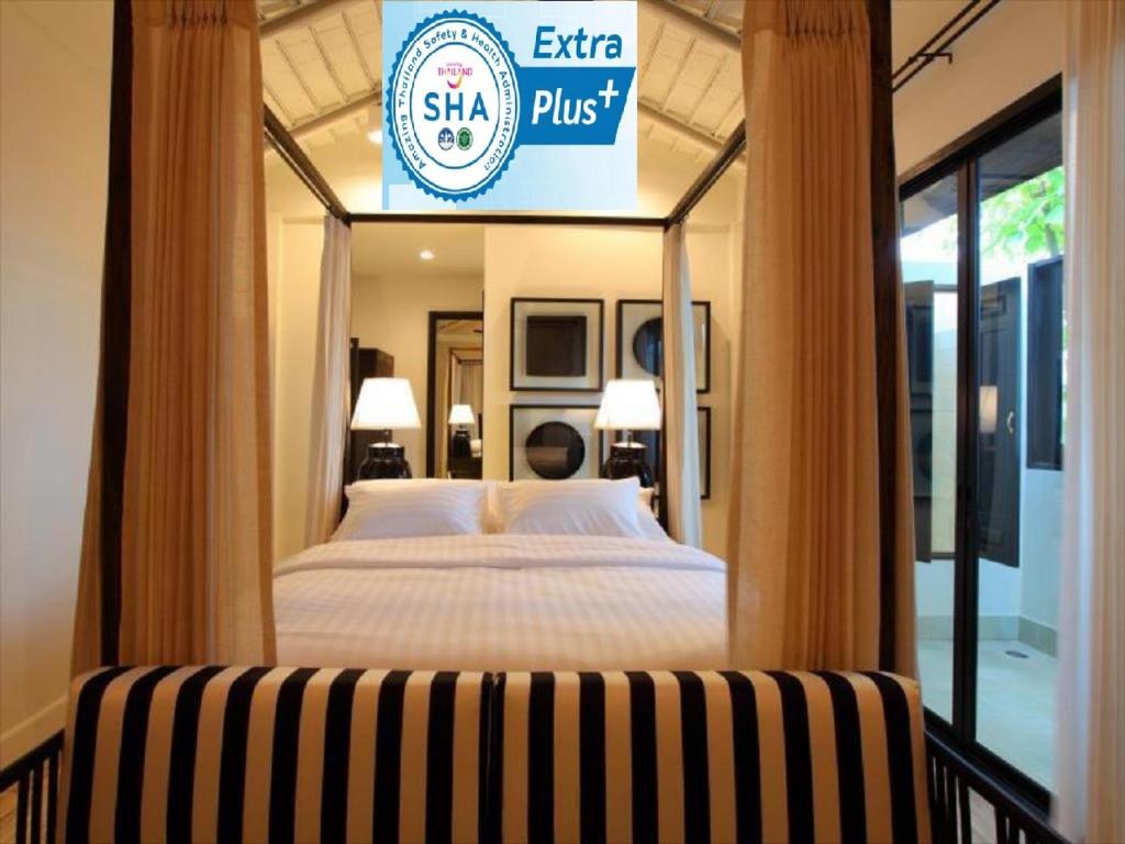 清迈99号画廊酒店- SHA Extra Plus的一间卧室,配有一张床和一个阅读shahi加的标志