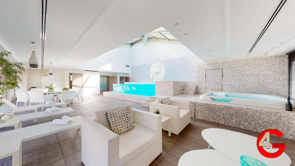 戛纳THE POOL HOUSE Cannes的客厅配有白色家具和浴缸