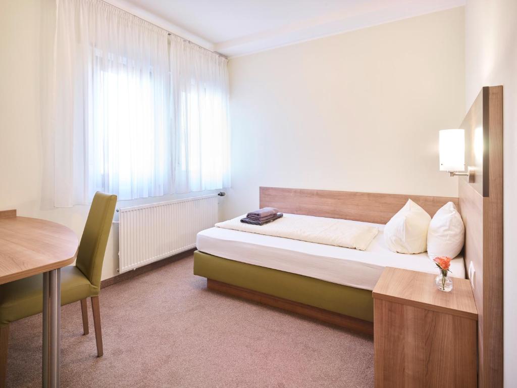 波恩Portofino的一间卧室配有一张床、一张书桌和一个窗户。