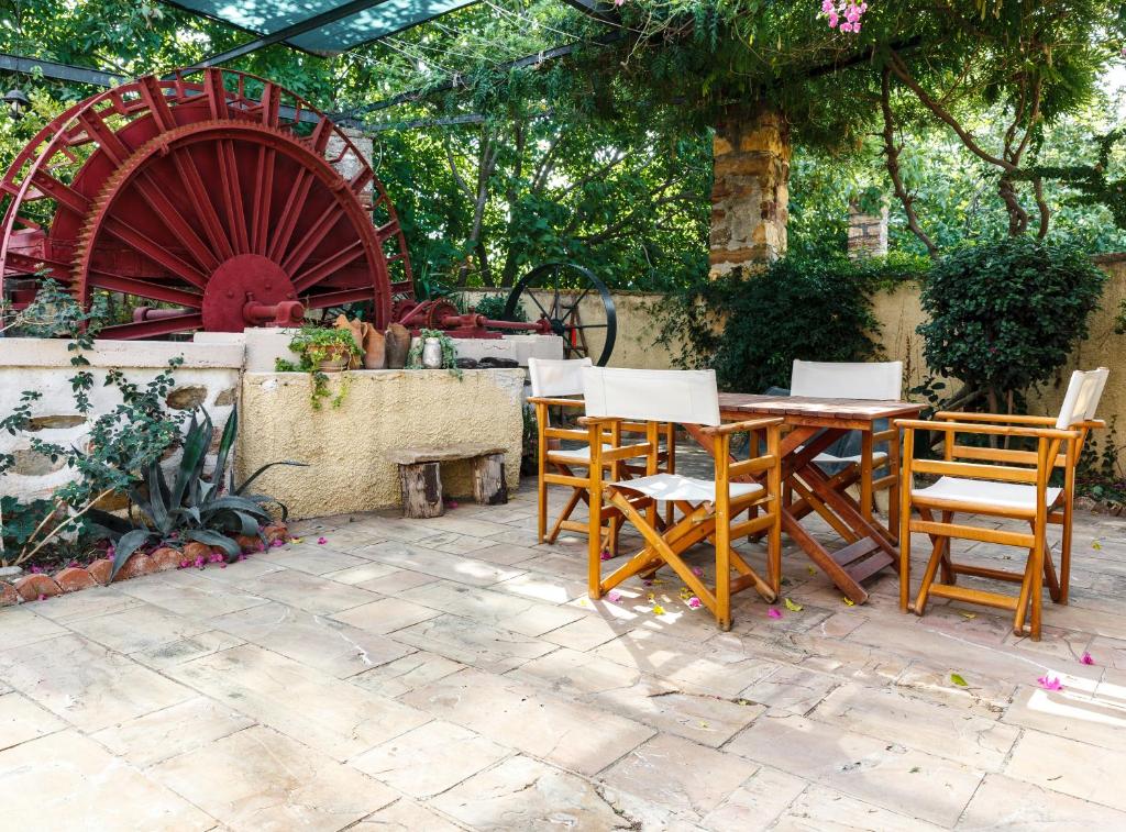 希俄斯Mansion Argyrakiko - 3 bedroom house in Kampos的庭院配有木桌、椅子和轮子