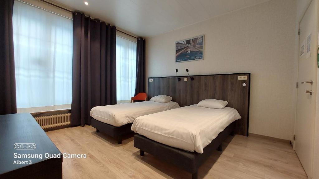 梅赫伦Albert - Rooms的酒店客房设有两张床和窗户。