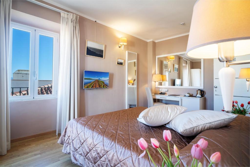 奥尔比亚中央酒店的一间卧室,床上有粉红色的鲜花