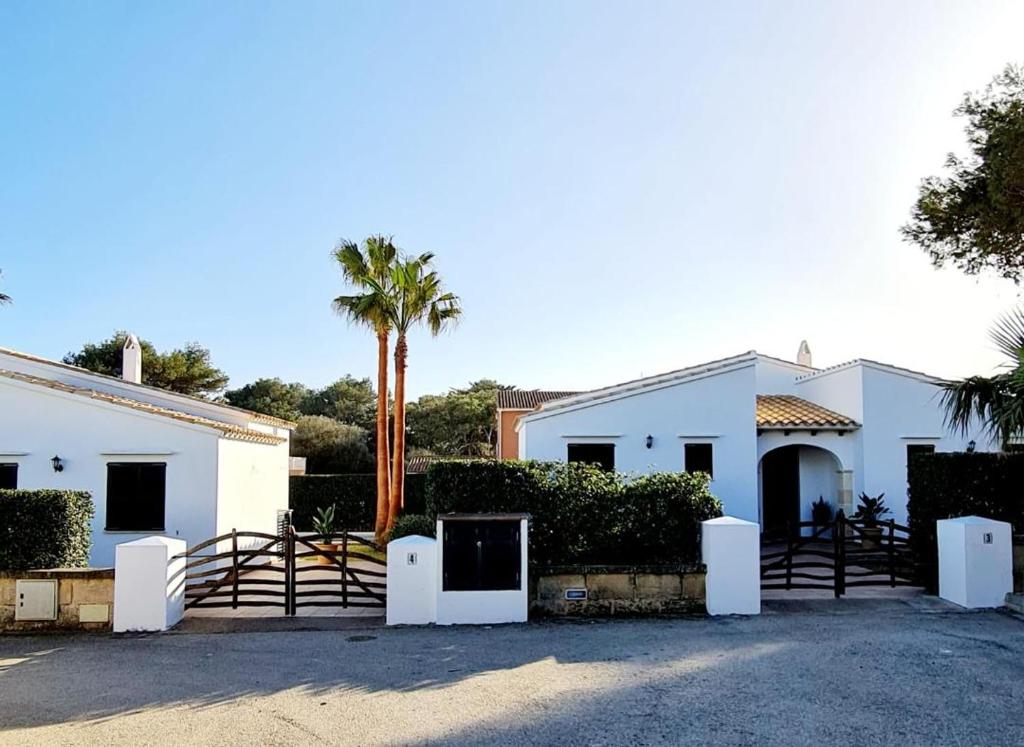 卡拉恩·布拉內斯Villas El Pinar的一座白色的房子,有门和棕榈树