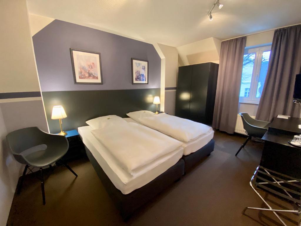 杜塞尔多夫Hotel Kaiserswerth的酒店客房设有一张大床和一张书桌。