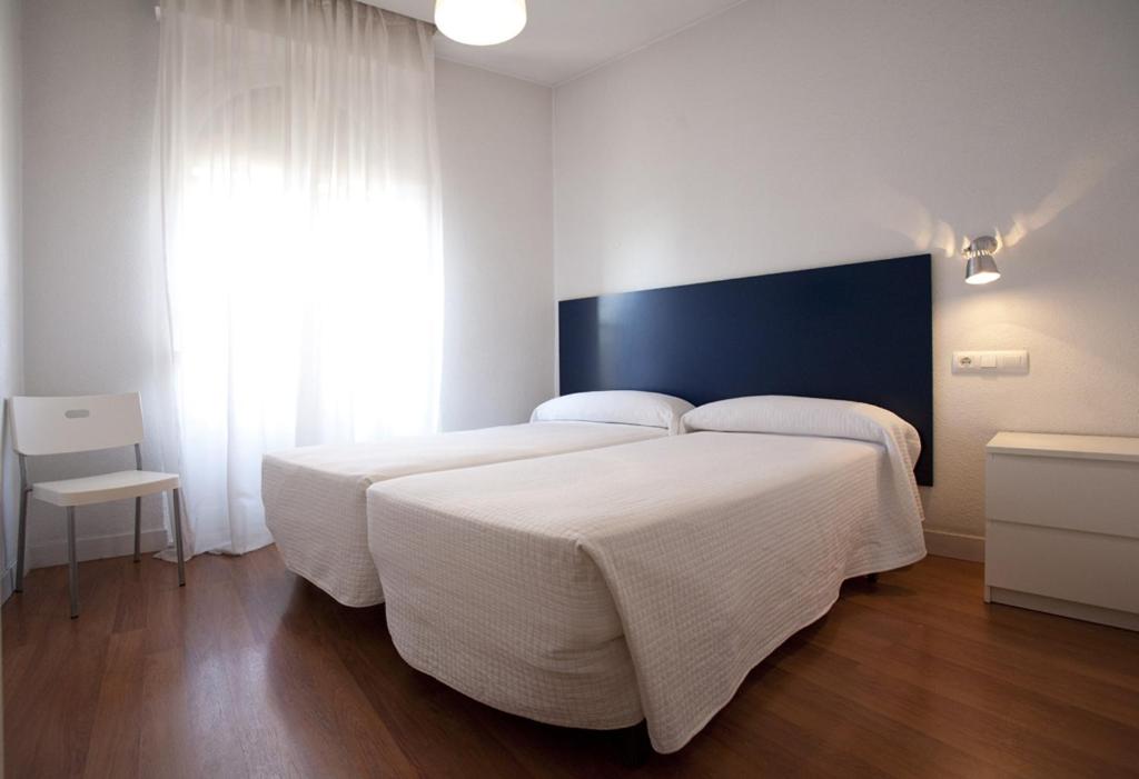 马德里桑塔伊莎贝尔旅馆的卧室设有一张白色大床和一扇窗户。