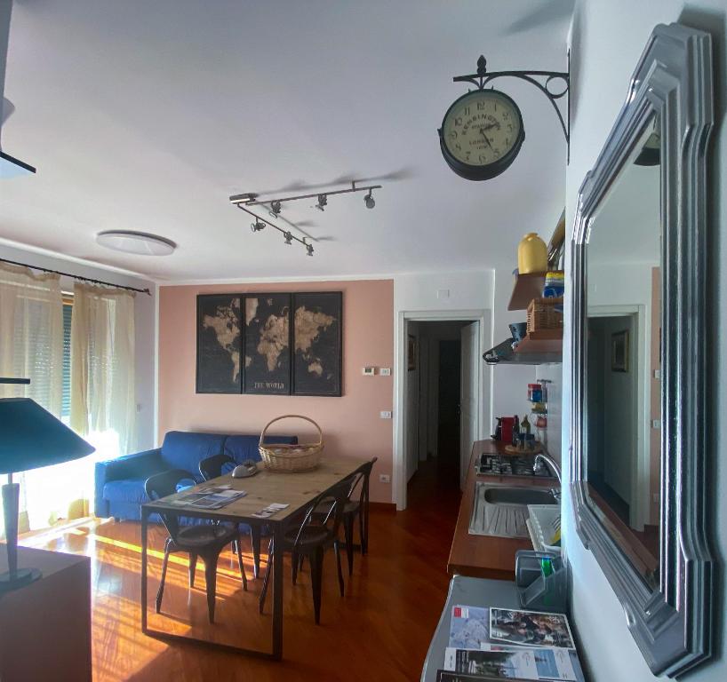 博尔扎诺Living Rencio: vicino al Centro di Bolzano的客厅配有桌子和墙上的时钟