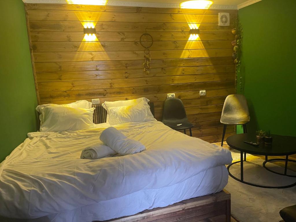 迈季代勒舍姆斯Cozy的卧室配有一张白色大床和木墙