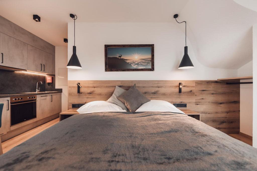 伊施格尔Alpenheim Apartment Ischgl的一间卧室配有一张大床和两个吊灯