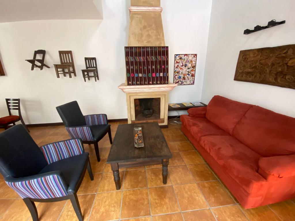 危地马拉安地瓜Suite don Pedro: Hermoso Loft con parqueo gratis!的客厅设有红色的沙发和壁炉