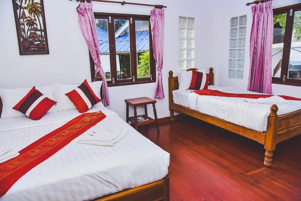 涛岛Pranee Bungalow的配有粉红色窗帘的客房内的两张床