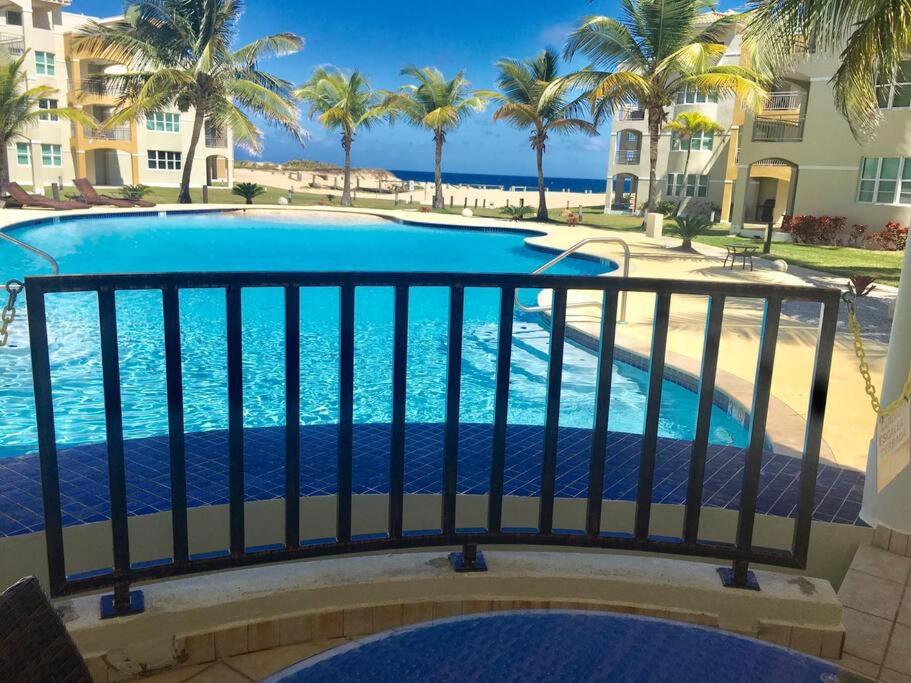 伊莎贝拉Haudimar PH Beachfront Apt 4BR/3Bath的从棕榈树阳台可欣赏到游泳池的景色