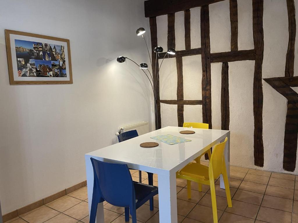 欧塞尔Appartement Le Coche d'Eau Auxerre Les Quais的客房内的白色桌子和黄色及蓝色的椅子