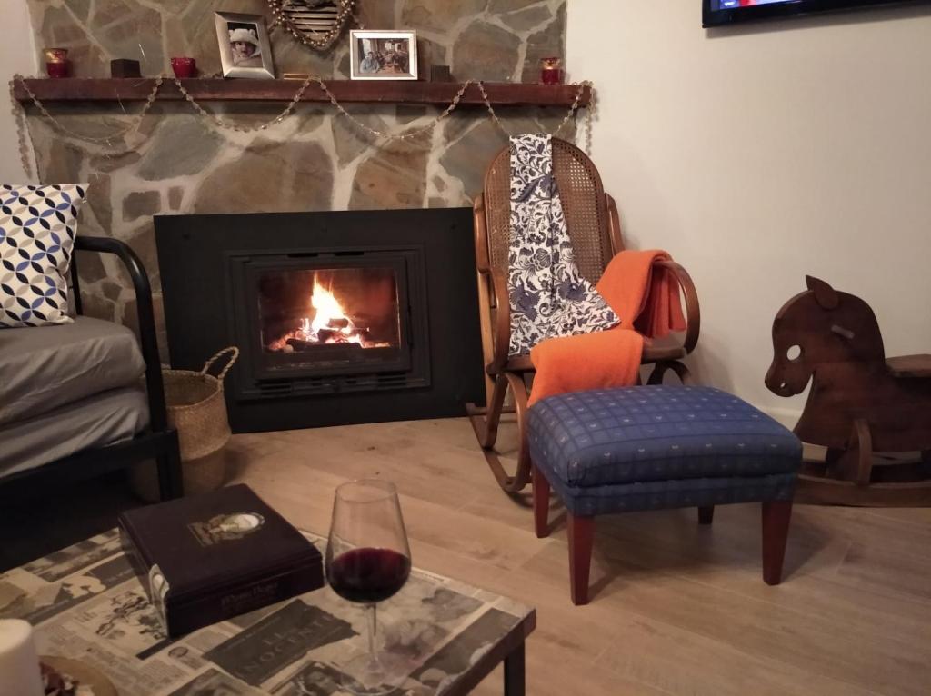 马拉加Casa Rural La ilusion的客厅设有壁炉和葡萄酒杯