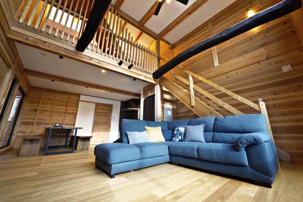 饭山市Tombi Lodge - Vacation STAY 14464v的配有木质墙壁的蓝色沙发