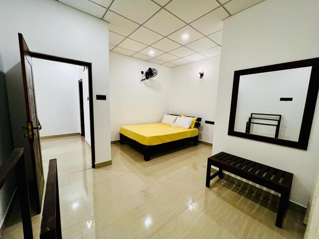阿努拉德普勒Theon Resort的一间卧室配有黄色的床和镜子