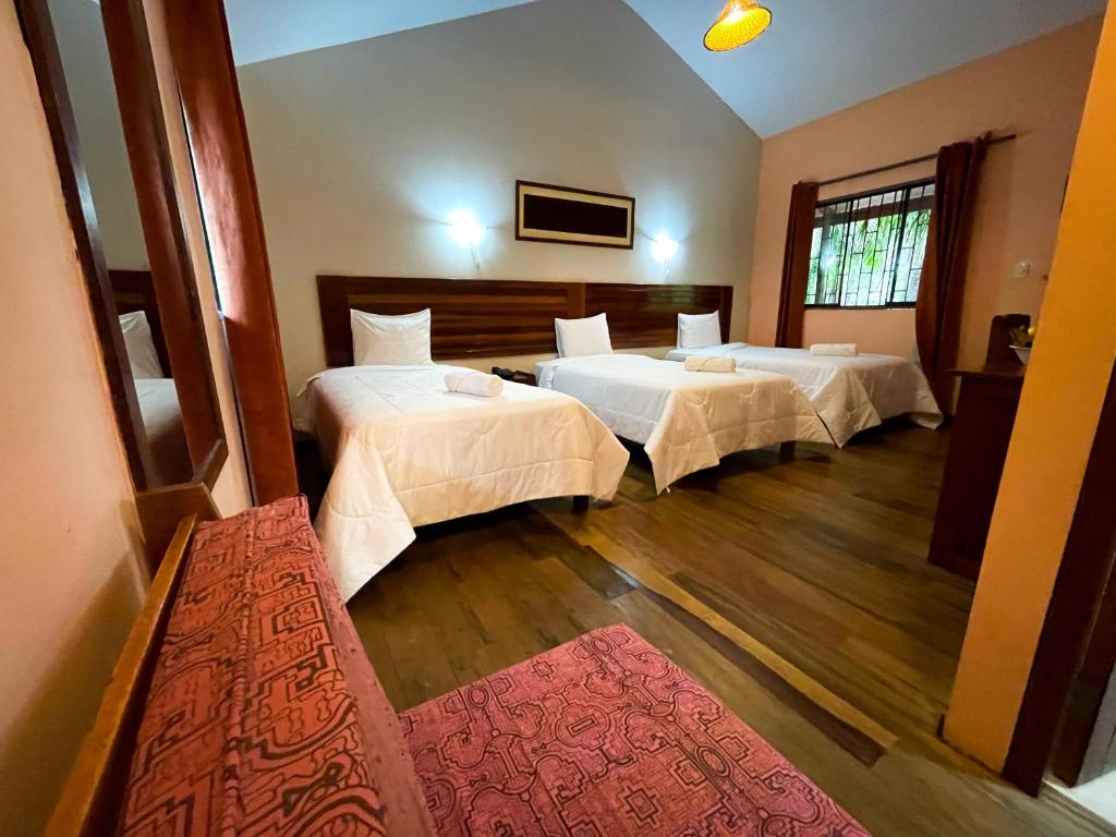 普卡尔帕马尼什生态酒店的酒店客房带两张床和红色地毯