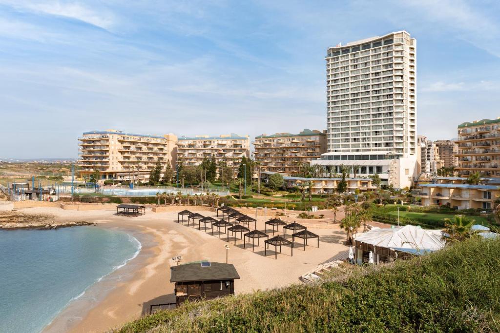 哈德拉Resort Hadera by Jacob Hotels的海滩上摆放着桌椅