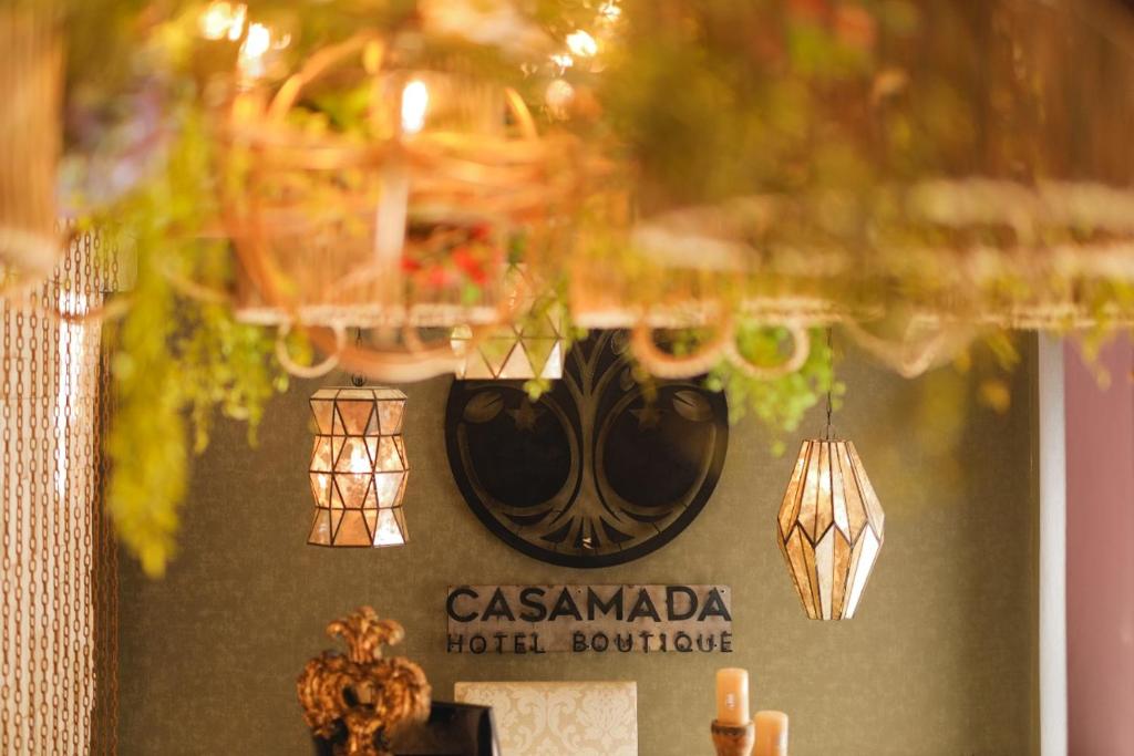 圣米格尔-德阿连德Hotel Casamada的墙上挂着吊灯的餐厅标志