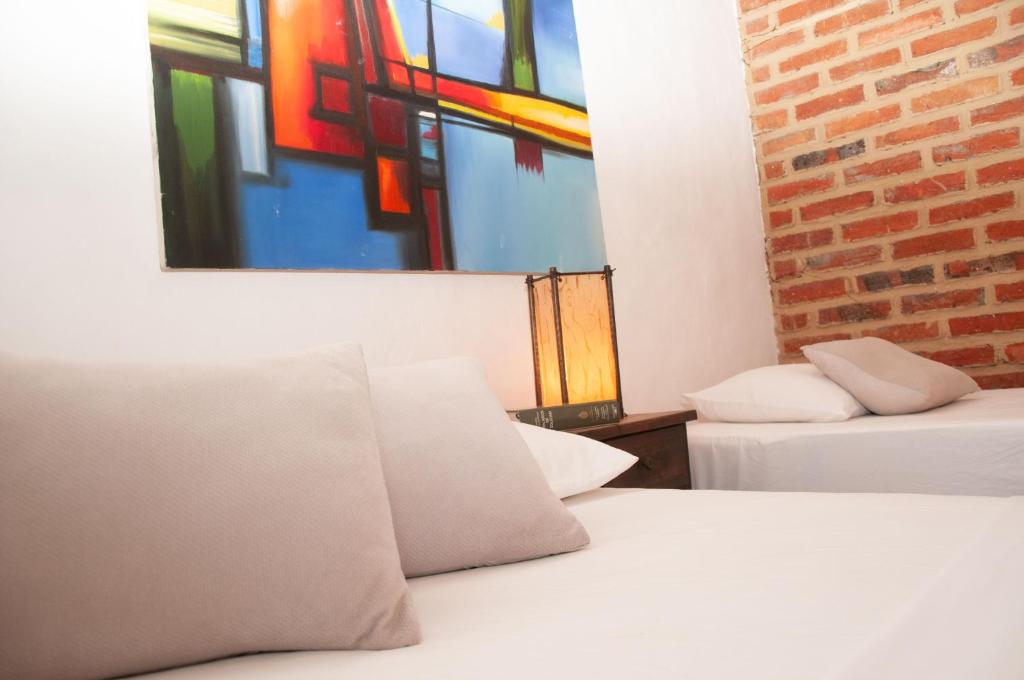 巴里查拉La Juanita Hostel Barichara的一间设有两张床的客房,墙上挂着一幅画