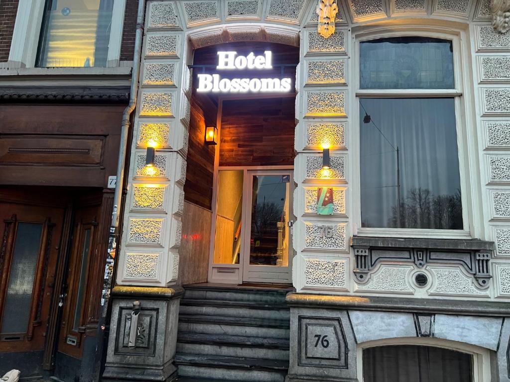 阿姆斯特丹Blossoms City Hotel的一座有标志的建筑,上面有读酒店开花的标志
