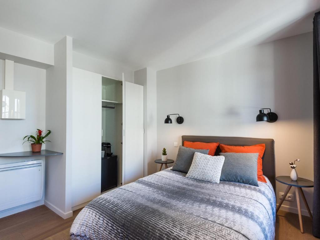 里尔Hyper centre chambre au calme的一间卧室配有带橙色和蓝色枕头的床