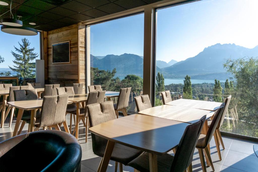 塞夫里耶Village Club Les Balcons du Lac d'Annecy - Neaclub的一间带桌椅的用餐室和大窗户