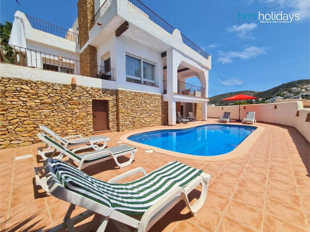 莫莱拉Villa Portina - HMR Holidays Moraira的别墅 - 带游泳池和2把躺椅