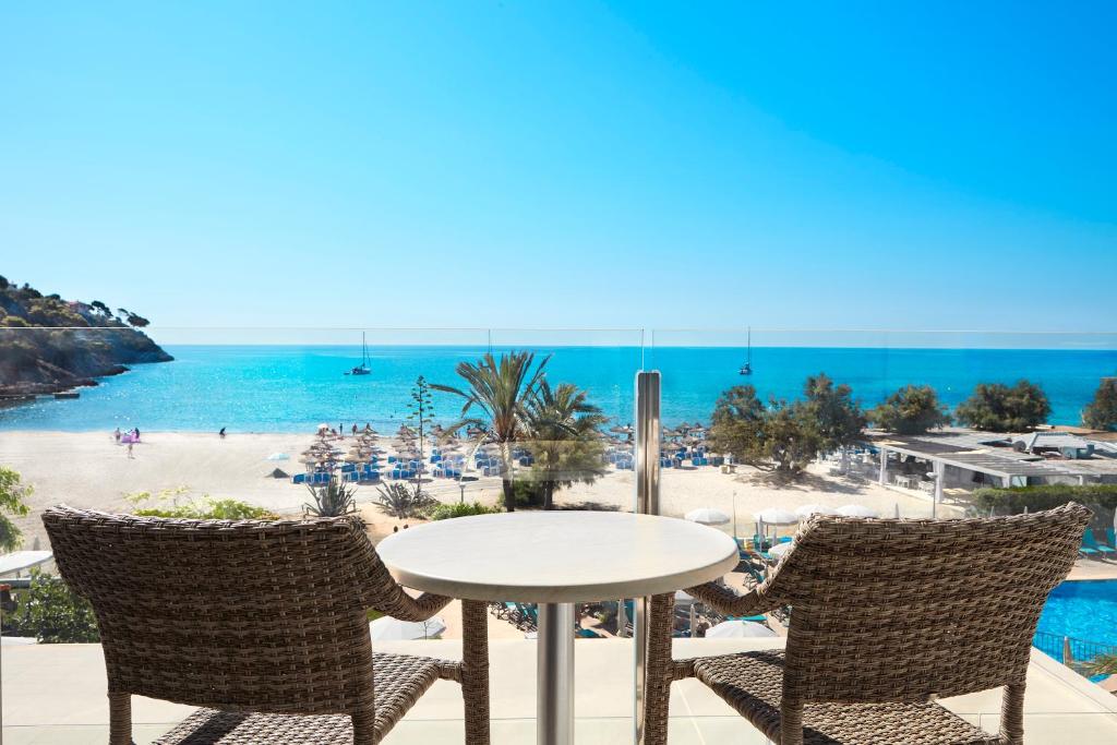 坎亚梅尔卡斯特尔皇家环球酒店的一张桌子和椅子,享有海滩美景
