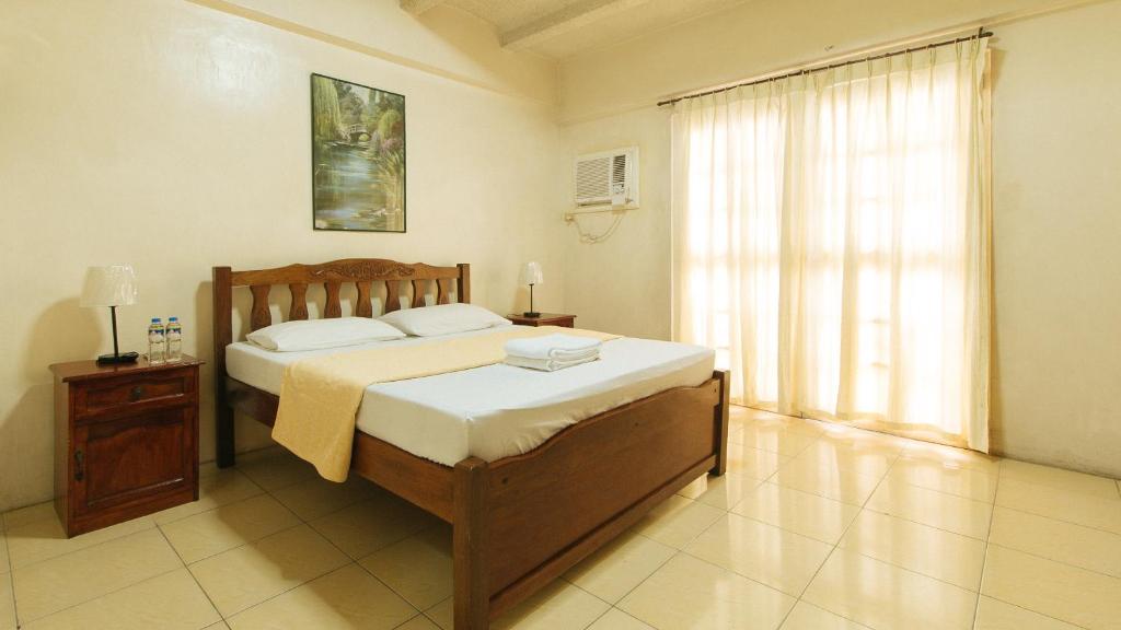 马尼拉Casa Micarosa Hotel and Residences by RedDoorz的一间卧室设有一张大床和一个窗户。