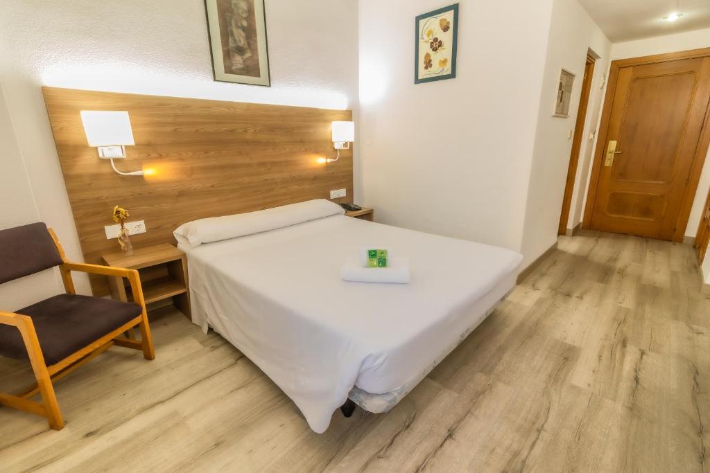 穆尔西亚帕克彻穆尔西亚酒店的卧室配有一张白色大床和一把椅子