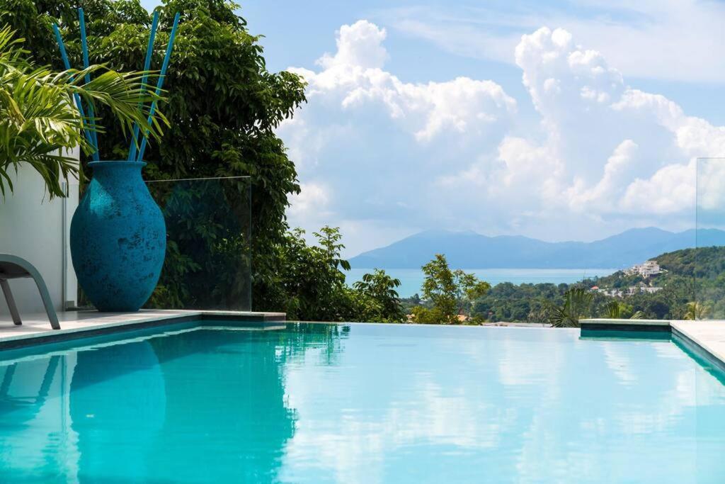 苏梅岛Villa SUAY - 2 swimming pool and SEA VIEW by VILLA FOR YOU的游泳池旁的大蓝色花瓶
