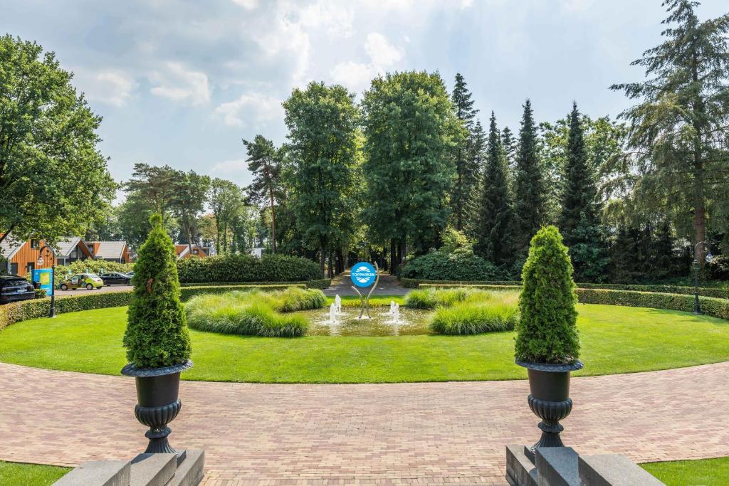 卢特伦拓普公园酒店 - 舍伦贝格地产的公园里带喷泉和树木的花园