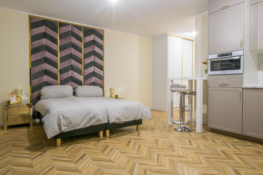 戈莱纽夫Central Apartments Goleniow Luxury的一间卧室配有一张床和一间厨房