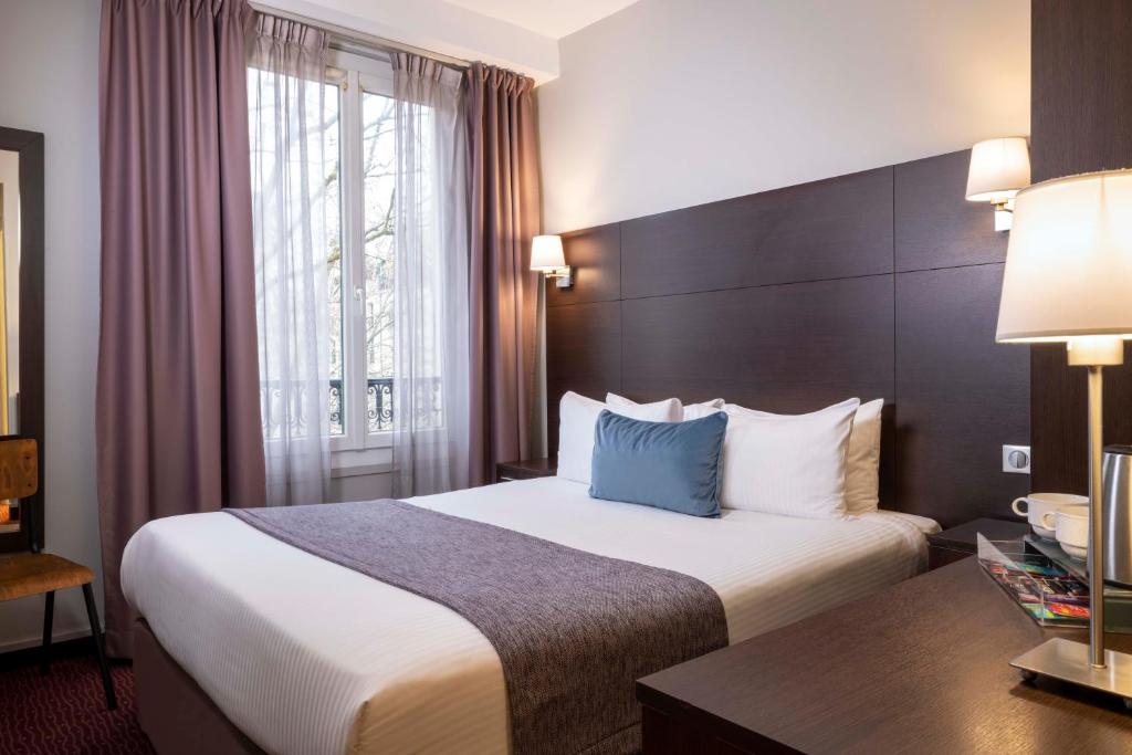 巴黎间奏曲酒店的配有一张床和一张书桌的酒店客房