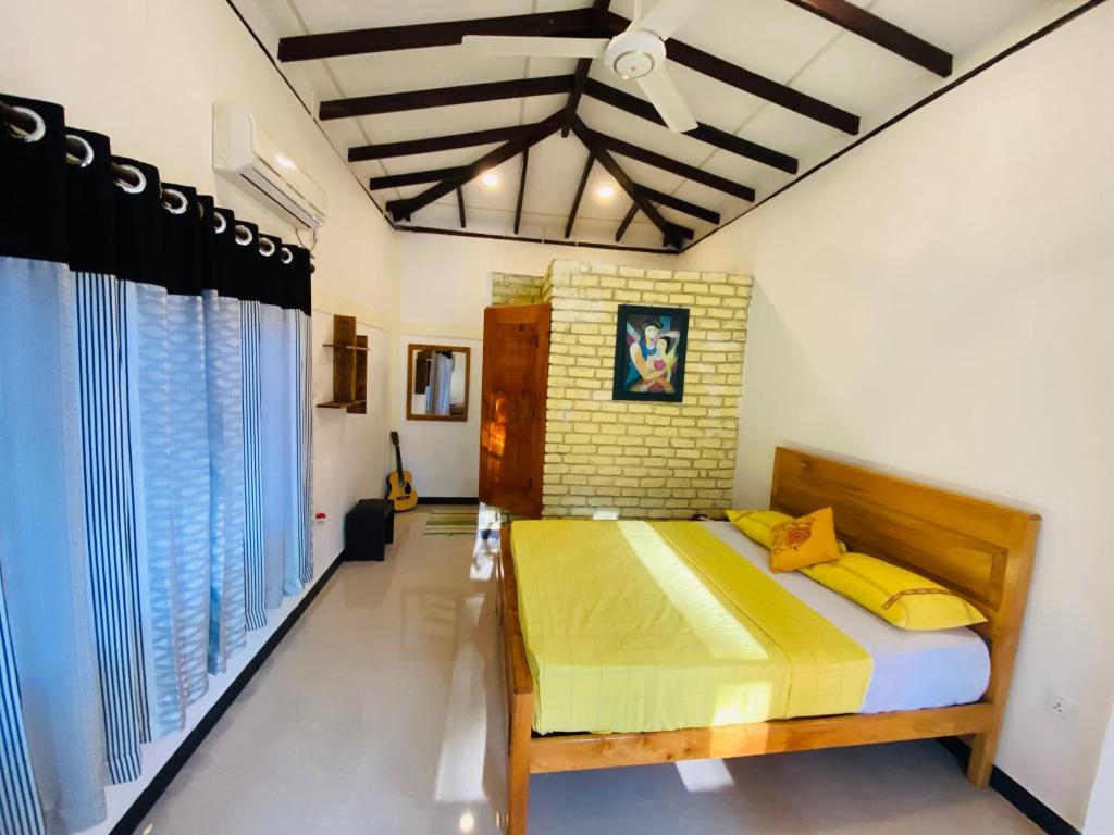 哈伯勒内Ritigala Hideaway的一间卧室配有一张带黄色枕头的床