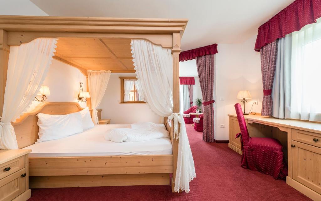 西兰德罗Residenze Mathilda的一间卧室配有天蓬床和红地毯