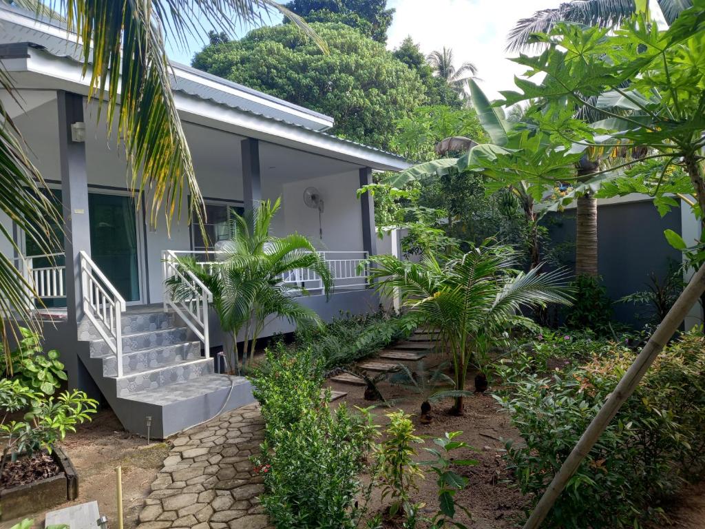 西塔努sweet home phangan的前面有楼梯和植物的房子