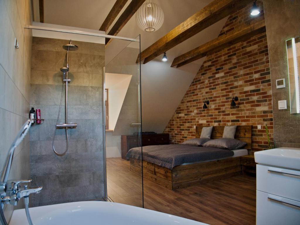 兹沃伦Apartman Vulcano的带淋浴的浴室和客房内的一张床