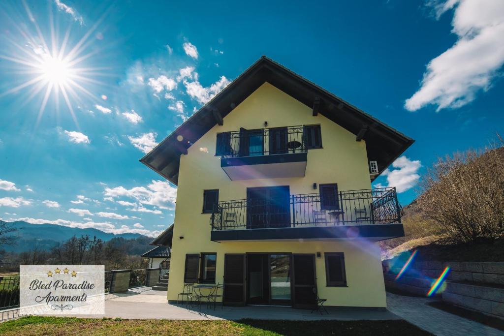 Bled-RečicaHostel Bled Paradise Slovenia的带阳台的房屋,阳光在天空中