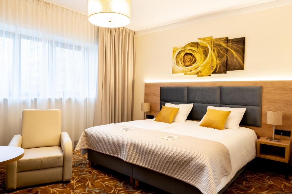 华沙巴尔纳必透中枢酒店的配有一张床和一把椅子的酒店客房