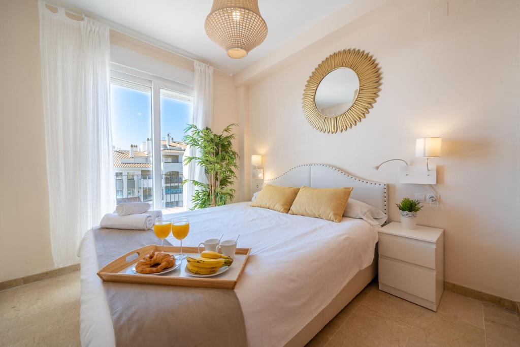 马尼尔瓦Apartamento con vistas al mar en Manilva Playa的一间卧室配有一张床,上面放着一个食物托盘
