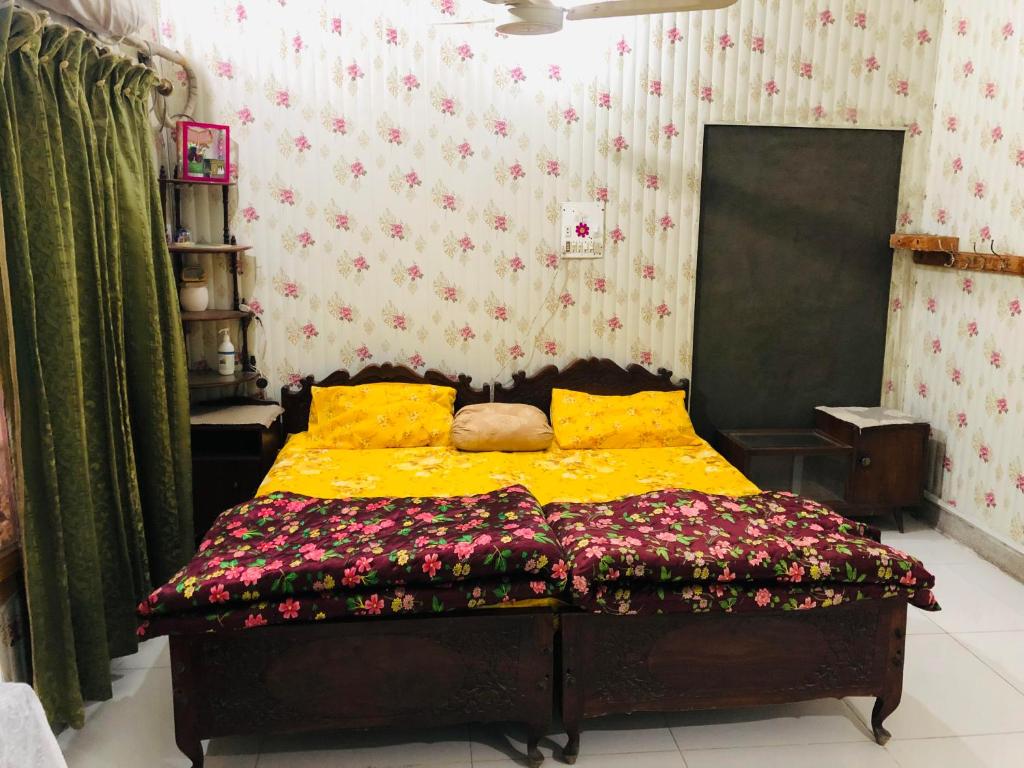拉瓦尔品第Al-Noor Cottage的一间卧室,床上放着鲜花