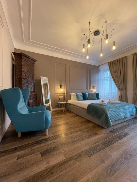 利沃夫Von Cruss apartments in Lviv的一间卧室配有一张床和一张蓝色椅子