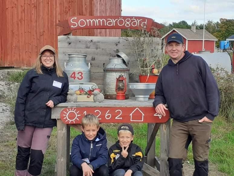 弗格罗Sommarö Stugor的坐在标志下的男人和女人及两个孩子