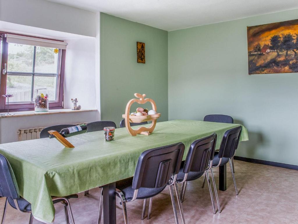 HeuemHoliday Home near Ravel Cycling paths的一间带绿色桌椅的用餐室