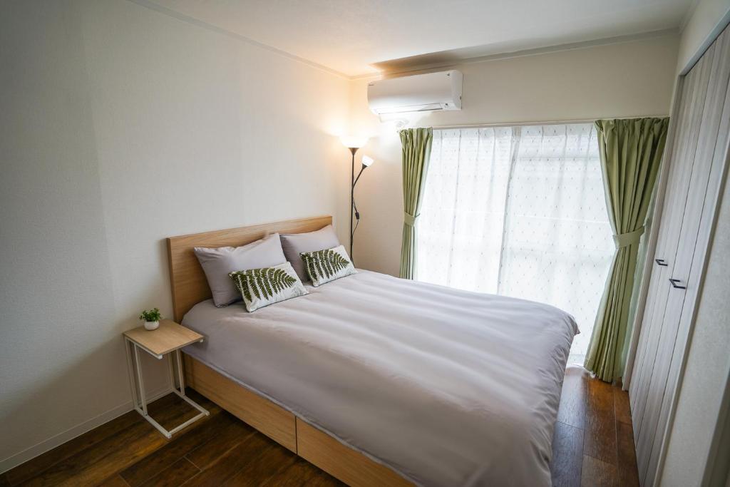 名古屋stay's サンジョイフル 304号 名古屋 民泊 駅近的卧室配有一张大白色床和窗户