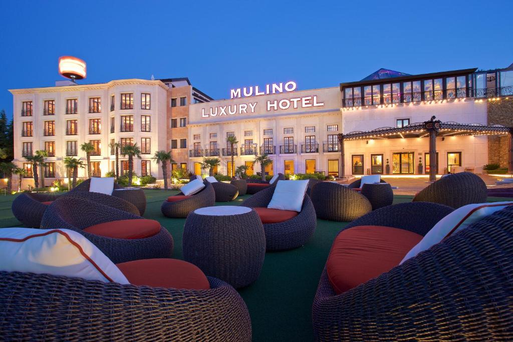 布耶Mulino Luxury Boutique Hotel的大楼前的带藤椅的酒店