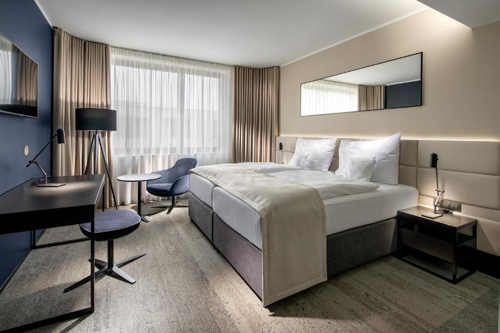 布拉格布拉格嘹亮国会酒店的酒店客房带一张床、一张书桌和一面镜子