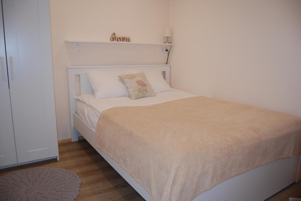 派尔努LiisuPesa Apartment with Sauna and Garden的一间卧室配有一张带白色床头板的床