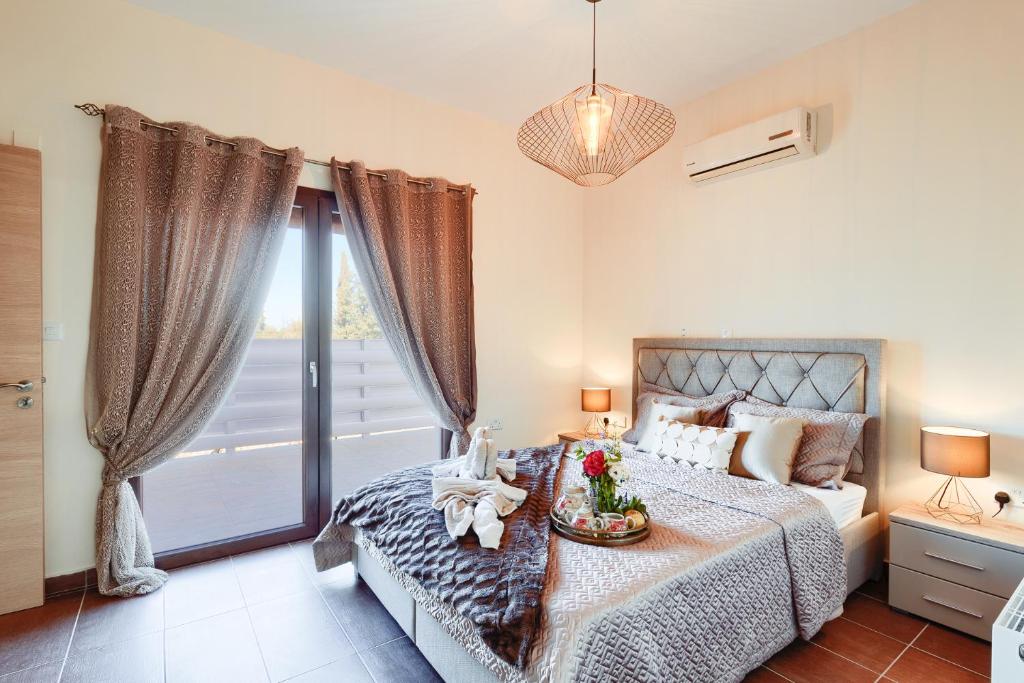 拉基Alkistias & Konstantinos Villa的一间卧室设有一张床和一个大窗户
